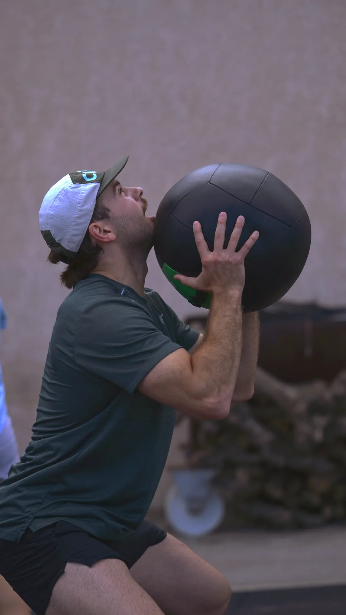 Adhérent lançant une wall ball en extérieur pendant un entraînement Hyrox